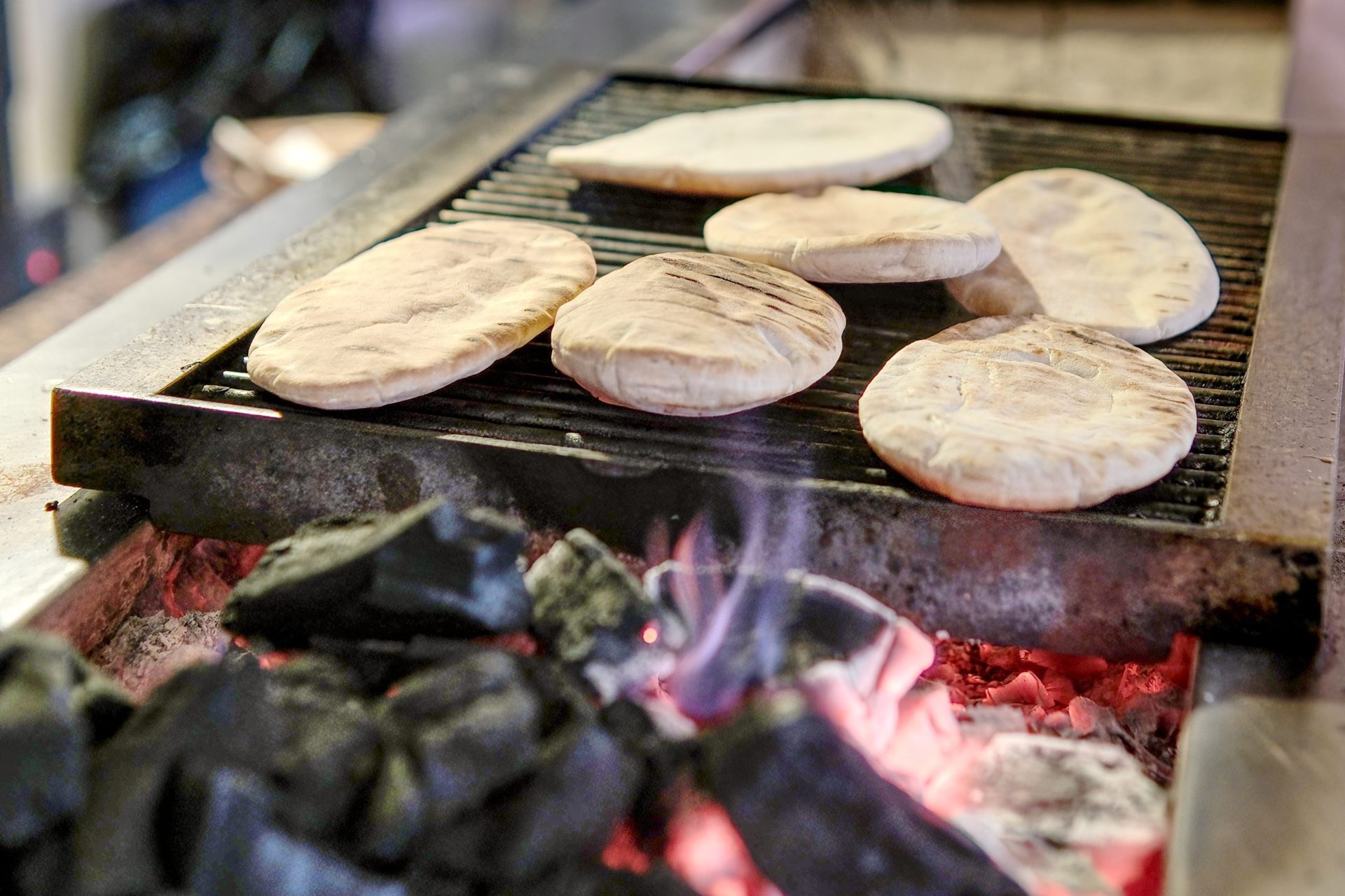 Pitta bread warming over charcoal